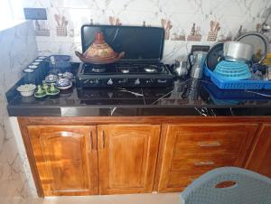 a kitchen counter with a stove and some dishes at Dar Salima in Chefchaouen +25 photos