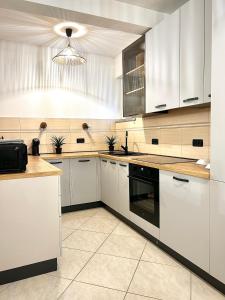 a kitchen with white cabinets and black appliances at Zen Suite in Umag