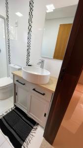 a bathroom with a sink and a mirror at Villa Serena Garden - Quarto Cama Queen - Banheiro Compartilhado in Cascavel +18 photos