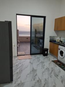 a kitchen with a view of the ocean through a glass door at Riba Mar in Cidade Velha