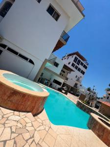 a swimming pool in front of a building at Mar Real Suites Guayabitos in Rincon de Guayabitos