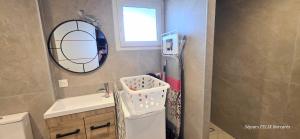 a small bathroom with a sink and a mirror at LE BARCARES Logement "Marenda" climatisé avec terrasse, plage à pied, place de parking - 4 personnes in Le Barcarès +14 photos