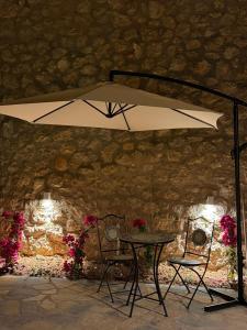 a table and two chairs under an umbrella at Piknik Suites in Dhërmi