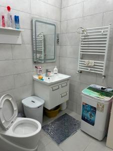 a bathroom with a toilet and a sink and a mirror at Appartement in Jijel
