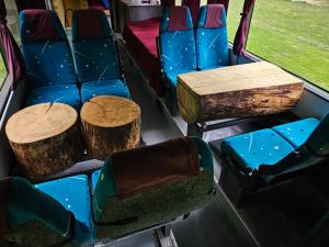 a group of seats with logs and tables on a bus at Bed in Bus in Kolárovice