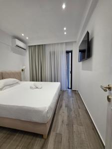 a bedroom with a bed and a television on a wall at Eantos Studios and Suites in Perea