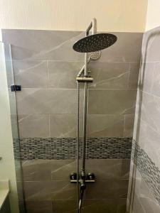 a shower with a shower head in a bathroom at Discovery Bay Villa and Beach Club in Discovery Bay +38 photos