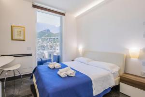 a bedroom with a bed with towels on it at Crescent Luxury Retreat - Seafront Apartment Scala E in Salerno
