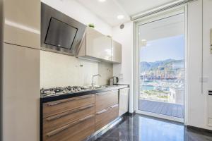 a kitchen with a sink and a large window at Crescent Luxury Retreat - Seafront Apartment Scala E in Salerno