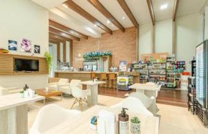 a store with white chairs and tables in a room at Studio Lifespace Batel Torre A in Curitiba