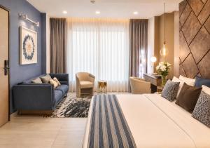 a hotel room with a large bed and a couch at THE POOL LABONE in Accra +18 photos