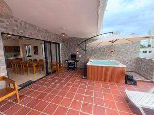 a patio with a hot tub and a table and chairs at Cabaña Costa Azul 2 in Coveñitas +17 photos