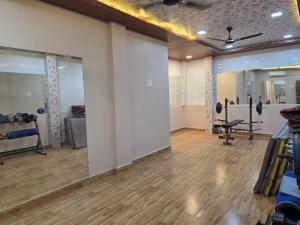 a large room with a gym with wooden floors at Shafi Villa in Neral