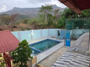 a swimming pool in front of a house at Shafi Villa in Neral