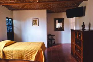 a bedroom with a bed and a dresser and a television at Casa Manzanos in Guanajuato