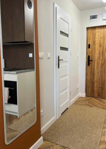 a kitchen with a mirror next to a door at Velvet Studio in Zamość