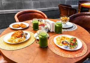 a wooden table with plates of food on it at Hotel Meson de Sara in Querétaro