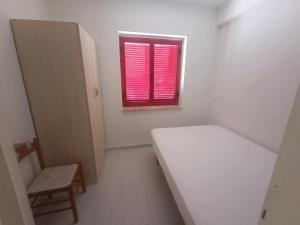 a small white room with a bed and a window at Effegi Casa Vacanze in Mandatoriccio Marina +8 photos