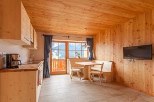 a kitchen and dining room with a table and chairs at BIO Ranerhof in San Candido