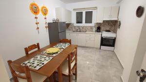 a kitchen with a table and chairs and a kitchen with white cabinets at Avaton Myrina Apartment in Myrina