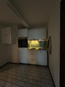 a small kitchen with white cabinets and appliances at Cozy & modern apartment in Willstätt in Willstätt +8 photos