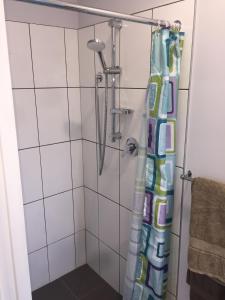a shower with a shower curtain in a bathroom at Papamoa Beach Sleepout in Papamoa