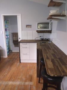 a kitchen with a wooden counter top with a microwave at Papamoa Beach Sleepout in Papamoa