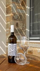 a bottle of wine and a wine glass on a table at Thea Syros in Ermoupoli