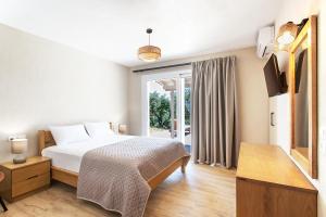 a bedroom with a bed and a large window at Villa Sunny in Skiathos