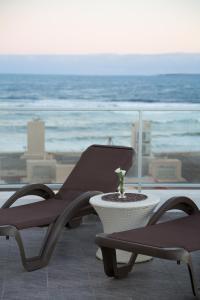 een patio met 2 stoelen en een tafel en de oceaan bij Seaview Hotel Boutique in Punta del Este