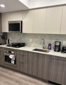 a kitchen with a sink and a stove top oven at Executive 2 bed luxury Suit in Surrey