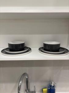 two black hats sitting on a shelf above a sink at Executive 2 bed luxury Suit in Surrey +13 photos