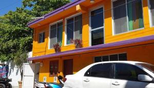 a white car parked in front of a yellow building at Isla Mujeres Punta Norte Private Bedroom 1 in Isla Mujeres