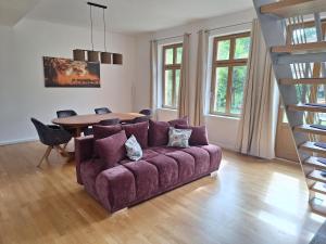 a living room with a purple couch and a table at Logierhaus Hoppegarten direkt an der Rennbahn mit perfekter S-Bahn Anbindung in Hoppegarten
