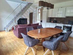 a kitchen and living room with a wooden table and chairs at Logierhaus Hoppegarten direkt an der Rennbahn mit perfekter S-Bahn Anbindung in Hoppegarten