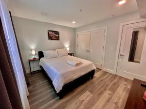 a bedroom with a bed with white sheets and wooden floors at The Cozy Suite - 1BR with Free Parking in Paterson +21 photos