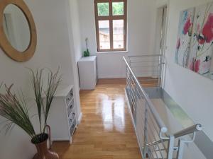 a room with a staircase with a mirror and a plant at Logierhaus Hoppegarten direkt an der Rennbahn mit perfekter S-Bahn Anbindung in Hoppegarten