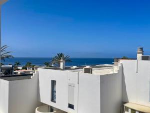 a white building with the ocean in the background at C&M Dream House in Morro del Jable