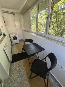 a small kitchen with a table and two chairs and a microwave at Apartament The Infinity Nest in Târgu Jiu +1 photo