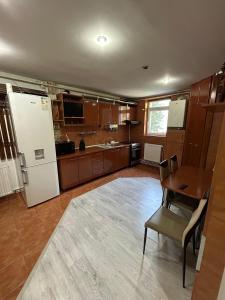 a large kitchen with a table and a refrigerator at Apartament The Infinity Nest in Târgu Jiu