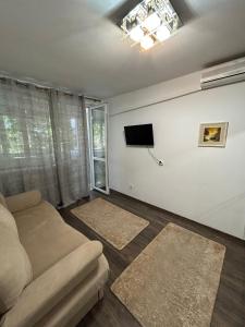 a living room with a couch and a tv at Apartament The Infinity Nest in Târgu Jiu