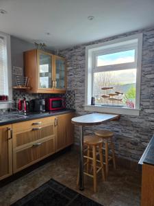 a kitchen with wooden cabinets and a table and a window at Tigh Na Mara in Furnace