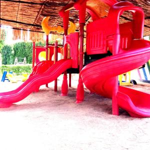 a red slide on a playground at Xperience St. George Sharm El Sheikh in Sharm El Sheikh