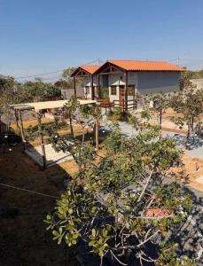a house in the middle of a yard with trees at Vila Maytrea Chalés in Alto Paraíso de Goiás +2 photos