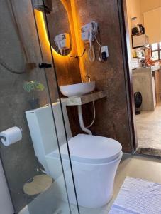 a bathroom with a toilet and a sink at Vila Maytrea Chalés in Alto Paraíso de Goiás