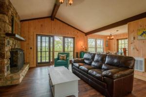 a living room with a leather couch and a fireplace at Mountain Stay Chalet in Beech Mountain