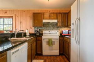 a kitchen with wooden cabinets and a white stove top oven at Mountain Stay Chalet in Beech Mountain