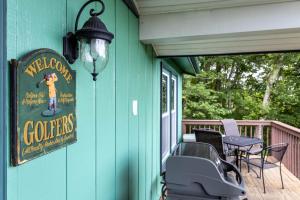 a green house with a sign on a porch at Mountain Stay Chalet in Beech Mountain +20 photos