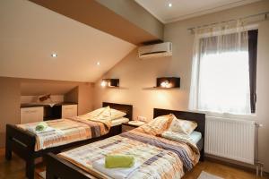 two beds in a room with a window at D apartmani in Sremska Kamenica
