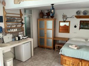 a room with a kitchen and a bed and a desk at Lindos Marianthi Studios in Lindos